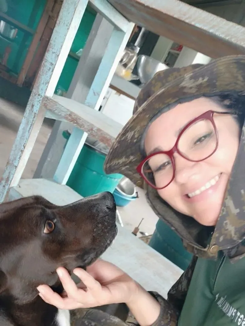 Ana de farda camuflada, com um cachorro